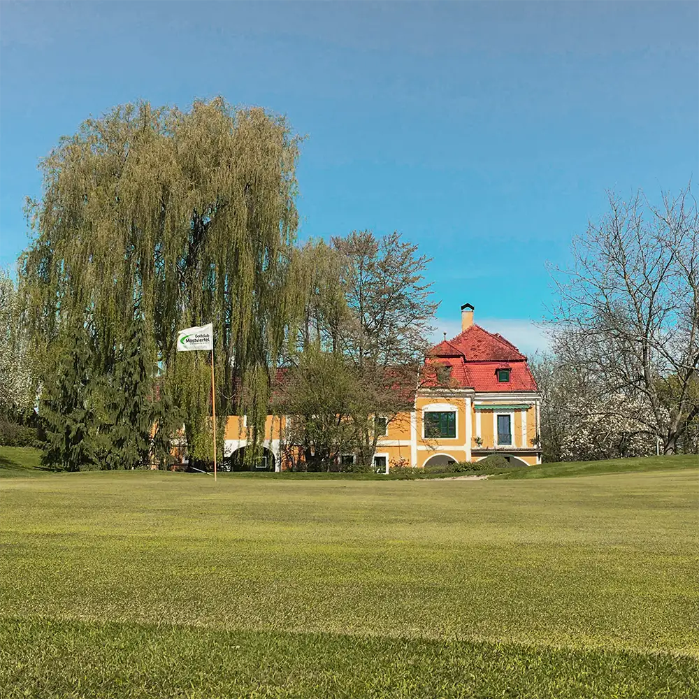 Das Grün von Loch 9 mit dem Gutshof als Clubhaus im Hintergrund